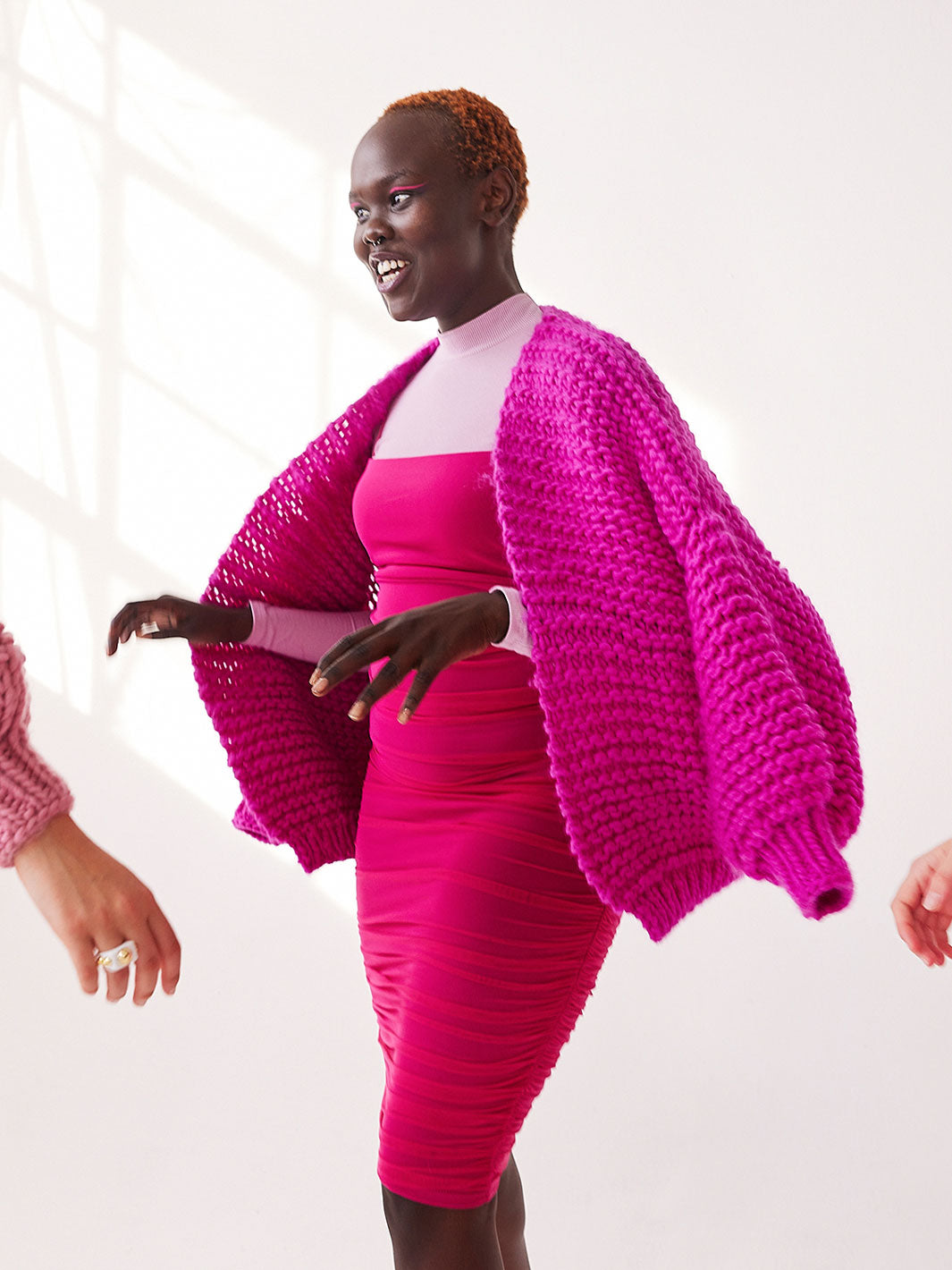 Girl laughing wearing a bright coloured chunky knit cardigan