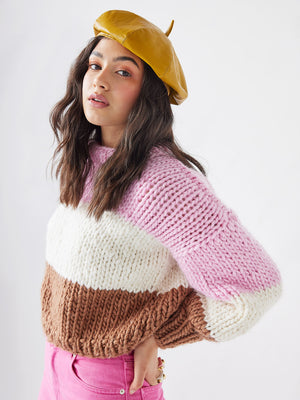 Girl in beret wears a chunky knitted jumper from cardigang