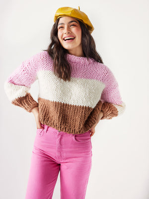 Girl laughing wearing pastel coloured knitted jumper and pink jeans