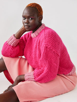 Girl sitting wearing bright chunky knit Betty jumper