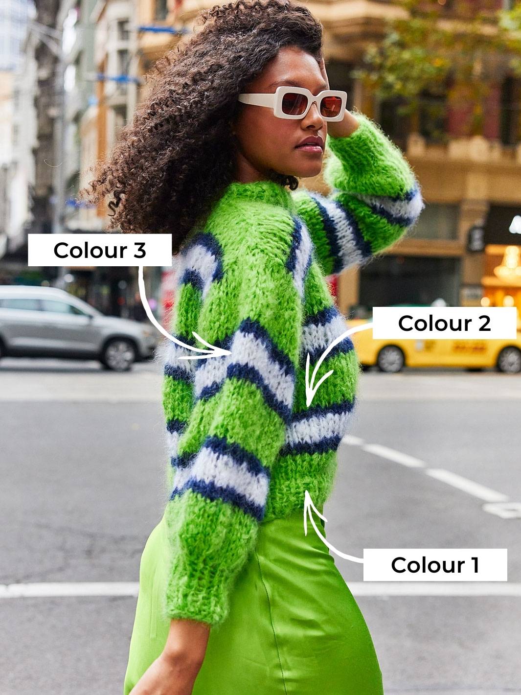Girl walking across road wearing neon green stripey chunky mohair jumper by Cardigang