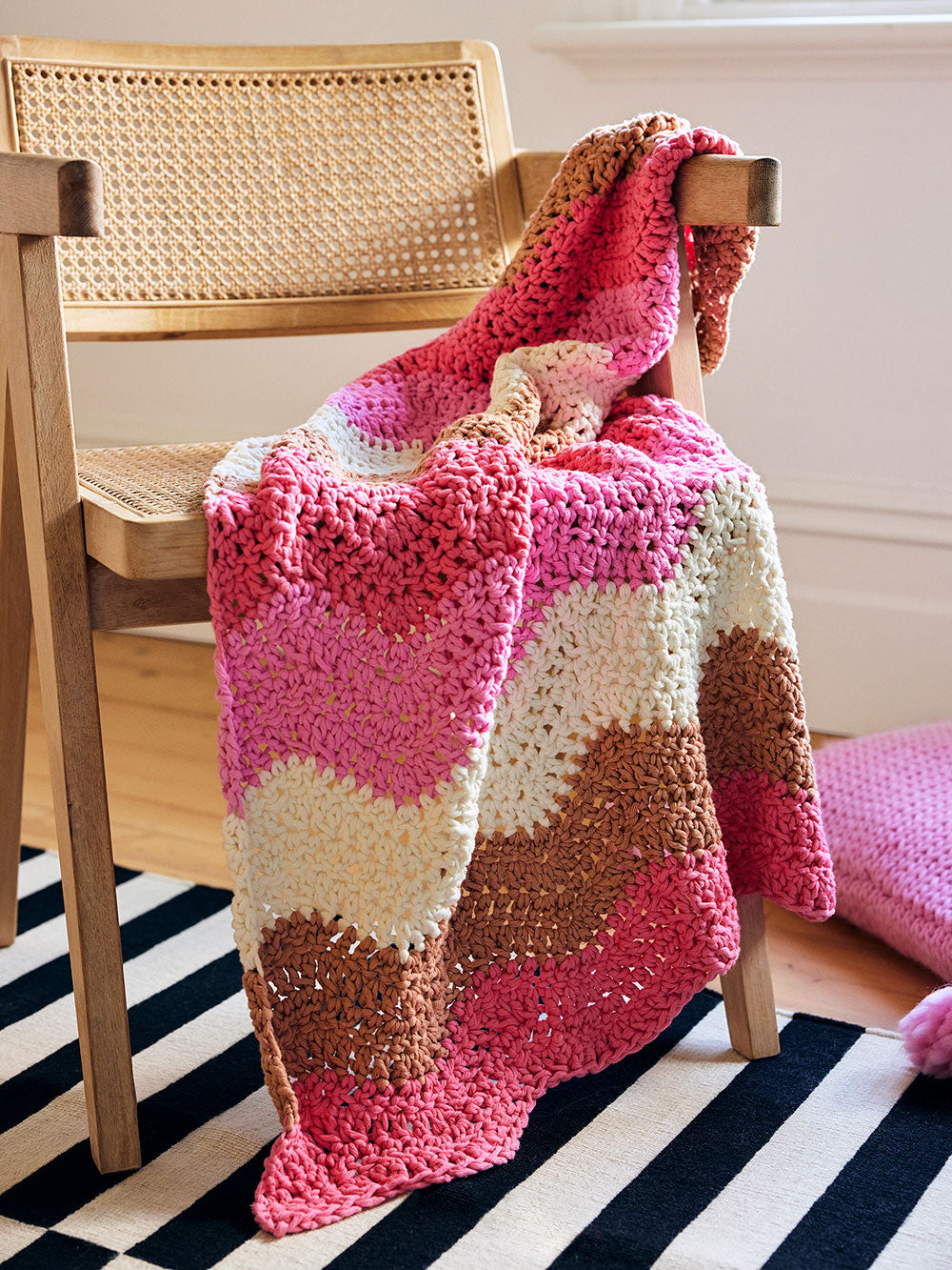 Image of Margot wave crochet baby blanket draped over a chair.