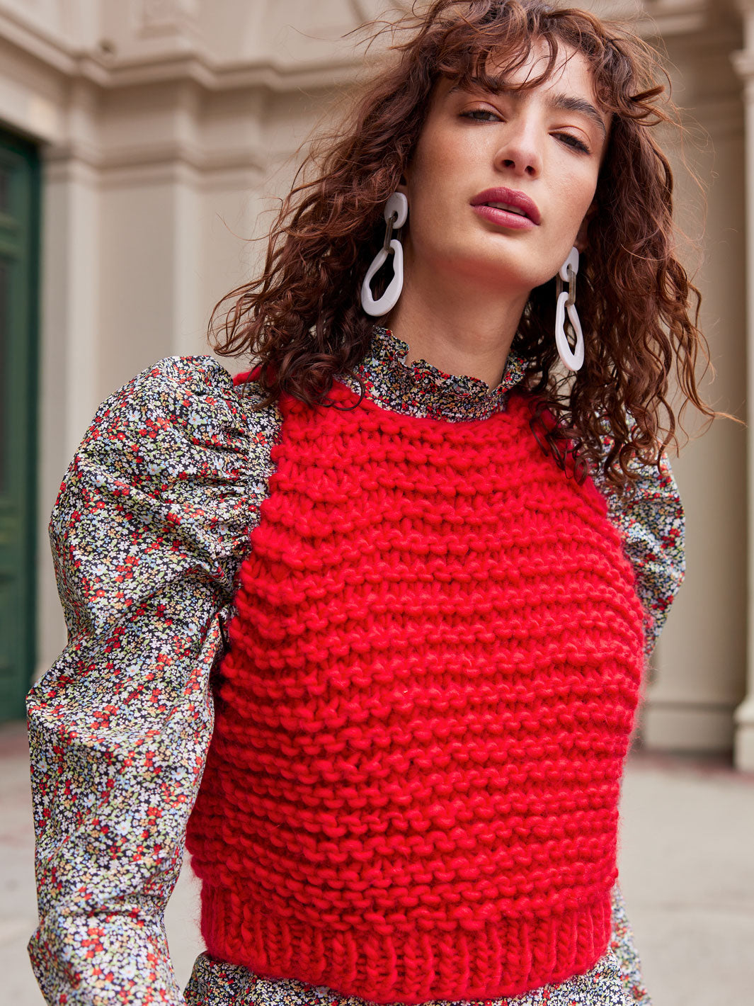 Girl walking to camera wearing a red knitted chunky vest