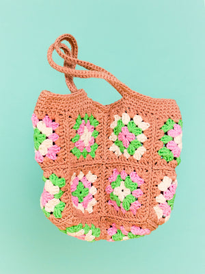 Photo of a crochet Granny Square shopping bag flying through the air