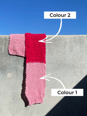Stacey scarf hangs off a balcony with arrows pointing to which colour is which